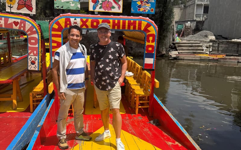 Two travellers on a colourful trajinera boat at Xochimilco, Mexico City